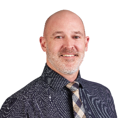 Man with a shaved head and beard wearing a patterned shirt and a checkered tie.
